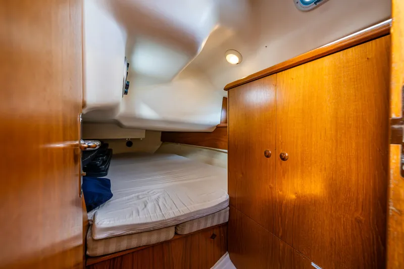 Slide: The Image of Cabin interior of 2001 Jeanneau Sun Odyssey 40 sailboat with wooden cabinetry and cozy bed. - 36