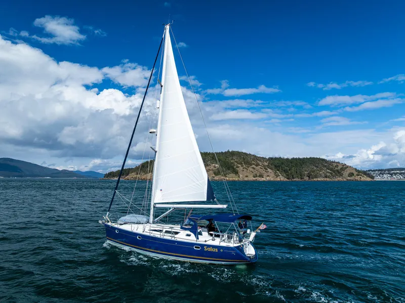 Slide: The Image of 2001 Jeanneau Sun Odyssey 40 sailing on blue ocean near scenic coastline. - 6