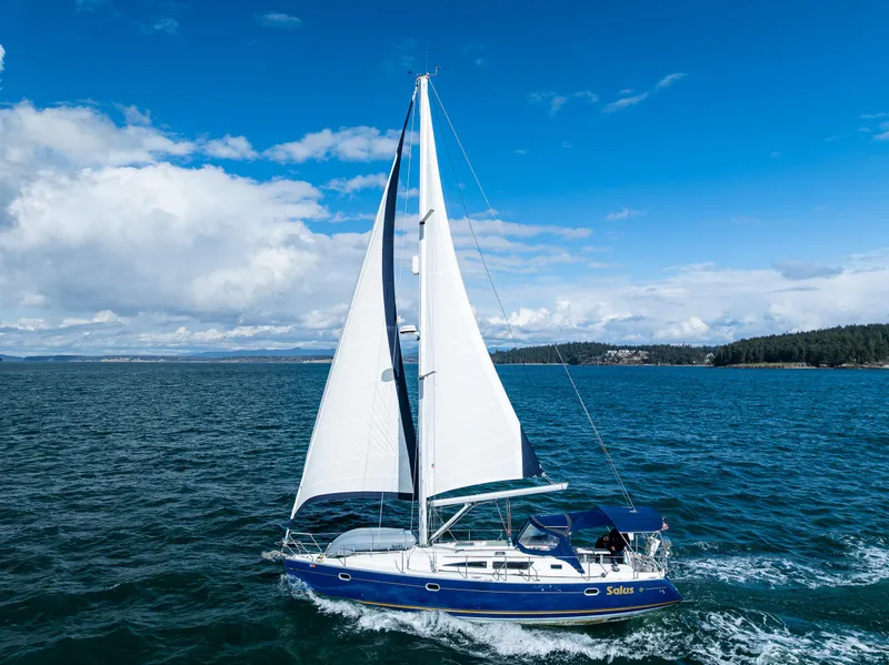 Slide: The Image of 2001 Jeanneau Sun Odyssey 40 sailing on open water under a clear blue sky. - 9