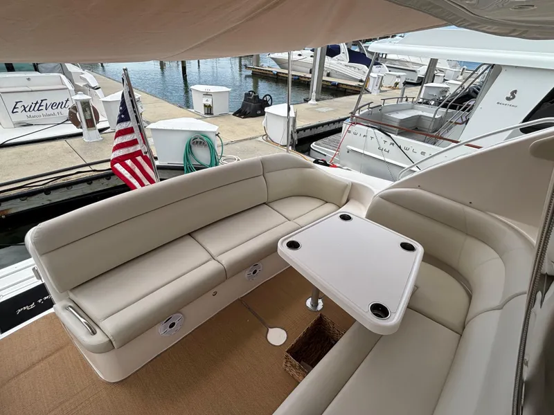 Slide: The Image of 2008 Tiara Yachts 3900 Sovran cockpit with seating and table, docked at marina. - 11