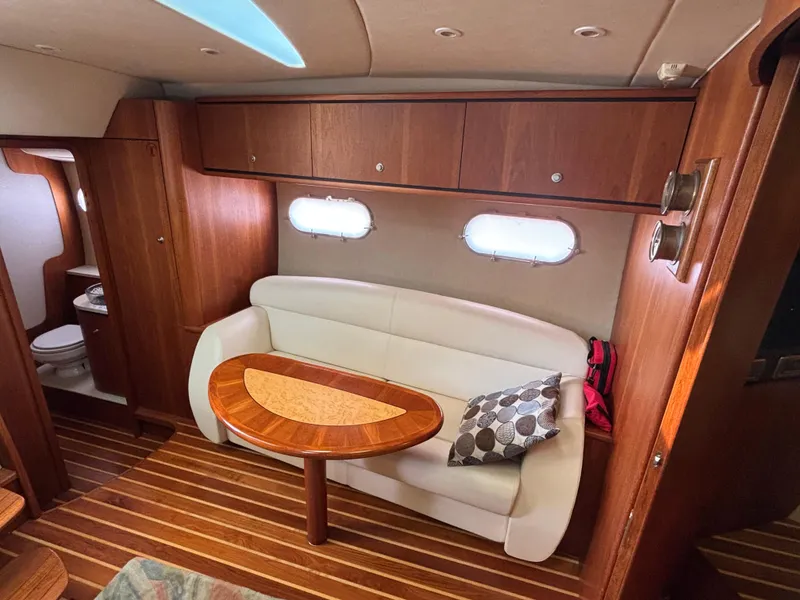 Slide: The Image of 2008 Tiara Yachts 3900 Sovran interior with wooden cabinetry, white sofa, and oval table. - 22