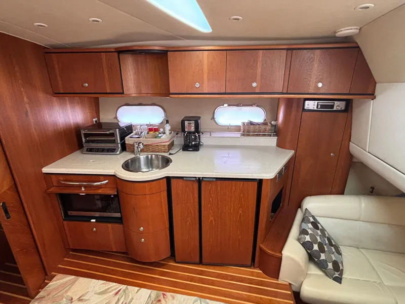 Slide: The Image of 2008 Tiara Yachts 3900 Sovran interior with kitchenette, featuring wood cabinetry and modern appliances. - 23