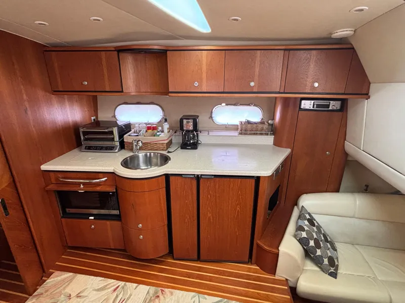 Slide: The Image of 2008 Tiara Yachts 3900 Sovran interior with kitchenette, wood cabinetry, and seating area. - 24