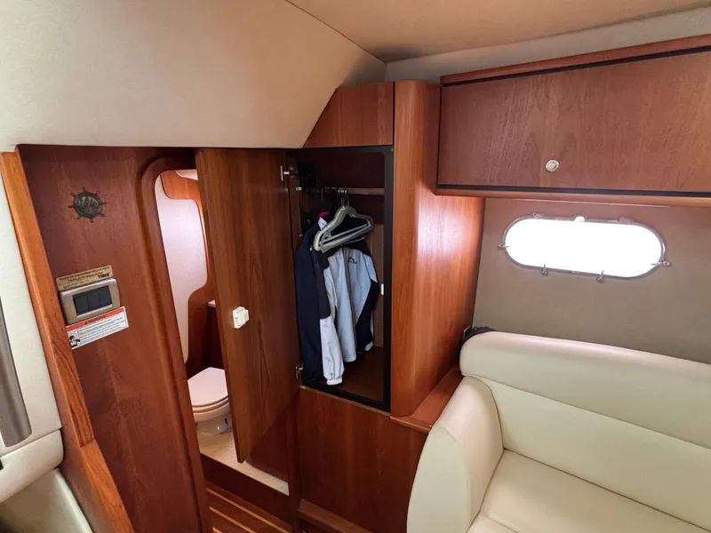 Slide: The Image of 2008 Tiara Yachts 3900 Sovran interior with wooden closet, clothes, and seating area. - 28