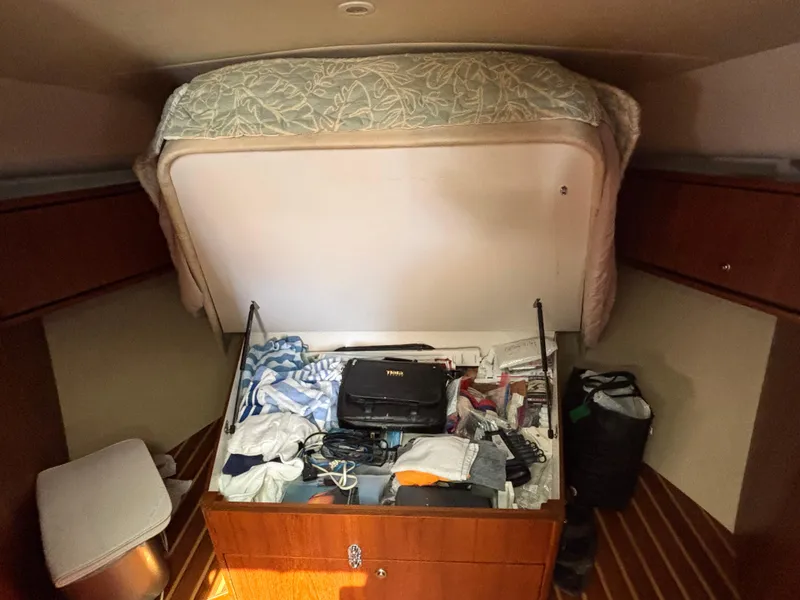 Slide: The Image of 2008 Tiara Yachts 3900 Sovran cabin with open storage, revealing various items. - 38