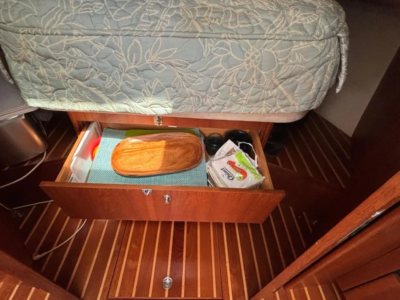 Slide: The Image of 2008 Tiara Yachts 3900 Sovran cabin drawer with storage items and wooden flooring. - 40