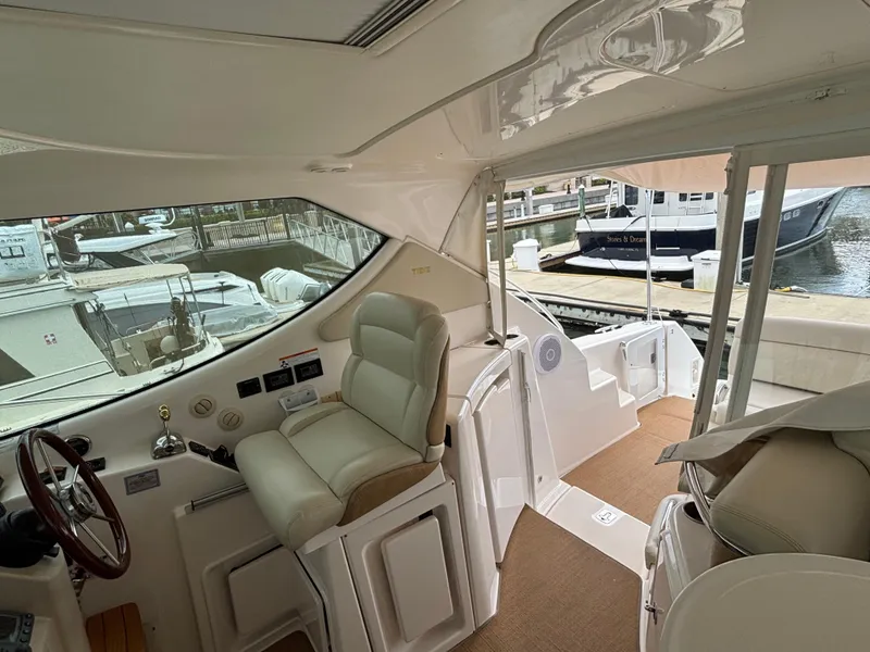 Slide: The Image of 2008 Tiara Yachts 3900 Sovran interior with helm, seating, and marina view. - 8