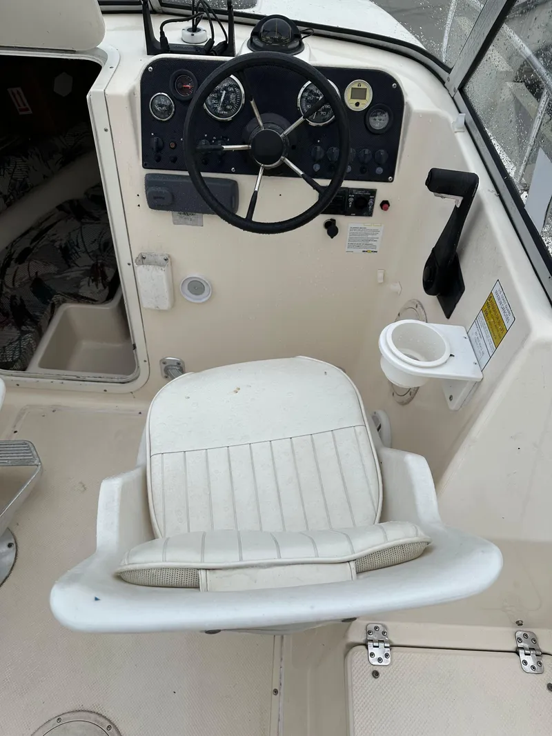 Slide: The Image of Cockpit of 1998 Key West 2020 Walkaround boat with steering wheel and captain's chair. - 11