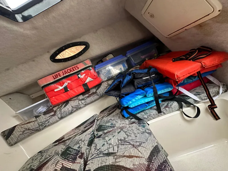 Slide: The Image of Interior of 1998 Key West Walkaround boat with life jackets and storage boxes. - 16