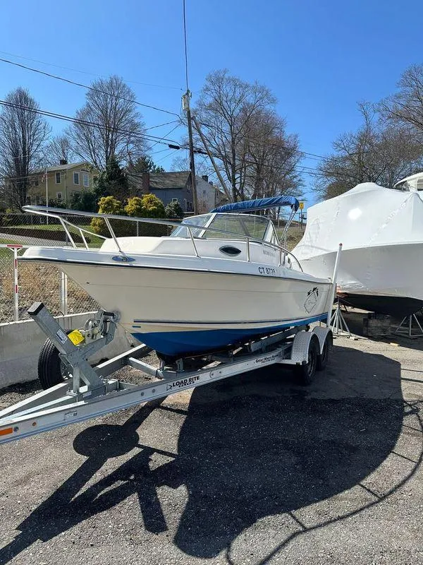 Slide: The Image of 1998 Key West 2020 Walkaround boat on trailer, parked outdoors on a sunny day. - 5