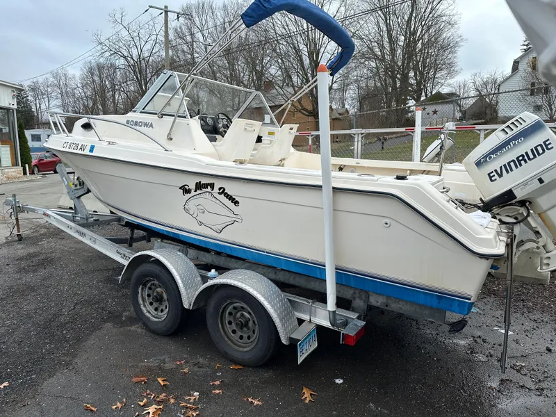Slide: The Image of Key West 2020 Walkaround boat on trailer, Evinrude motor, parked outdoors, overcast day. - 6
