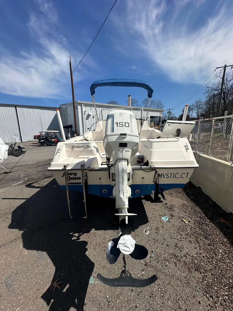 Slide: The Image of 1998 Key West 2020 Walkaround boat with outboard motor, parked outdoors. - 8