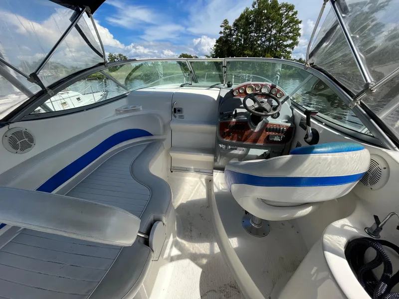 Slide: The Image of 2006 Bayliner 265 Cruiser interior with steering wheel, seating, and clear sky view. - 13