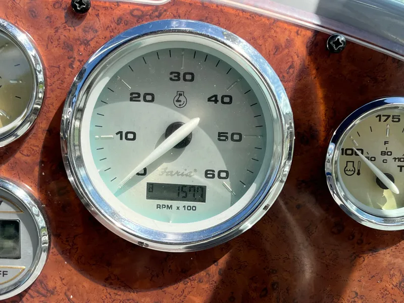 Slide: The Image of Tachometer of 2006 Bayliner 265 Cruiser showing 1590 RPM on wooden dashboard. - 19