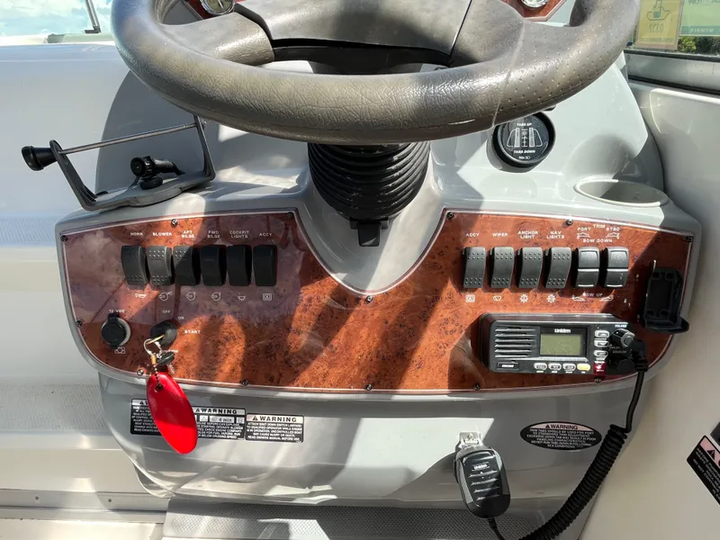 Slide: The Image of Control panel of a 2006 Bayliner 265 Cruiser with steering wheel and switches. - 21