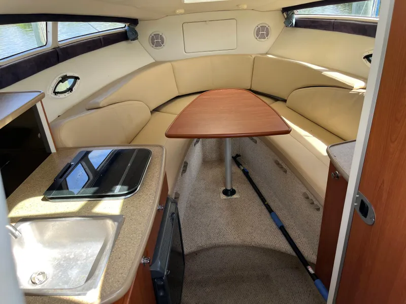 Slide: The Image of 2006 Bayliner 265 Cruiser interior with seating, table, and kitchenette. - 22