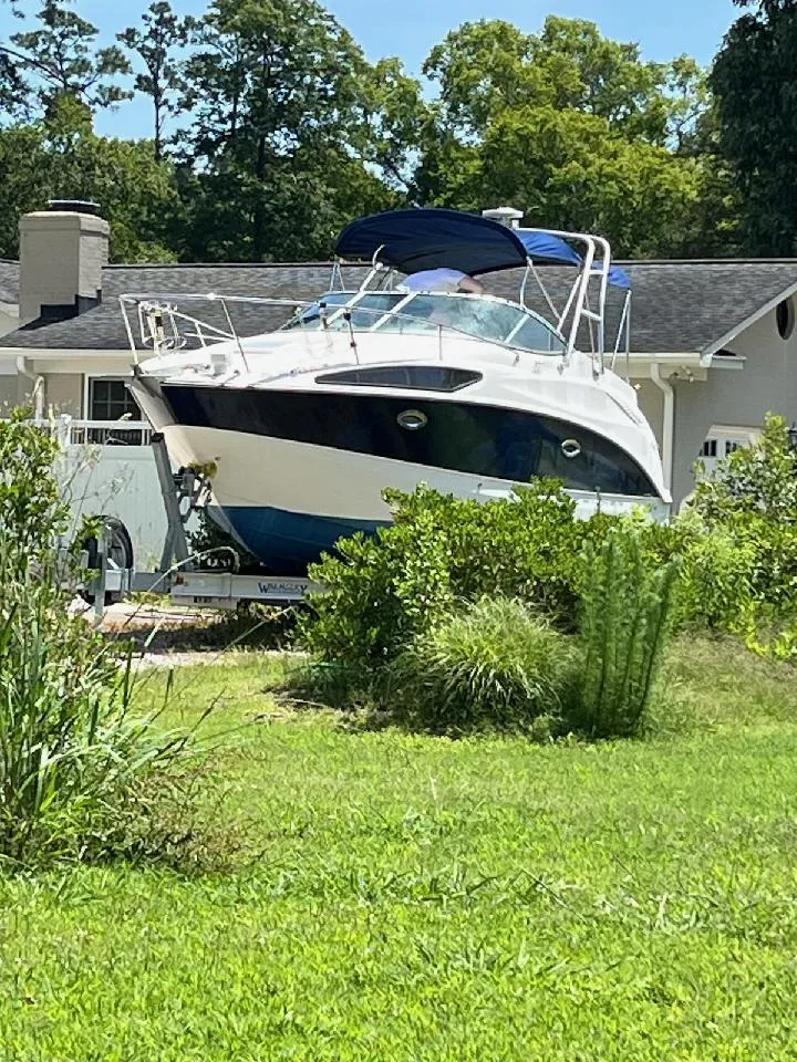 Slide: The Image of 2006 Bayliner 265 Cruiser boat on trailer, parked in a residential yard. - 5