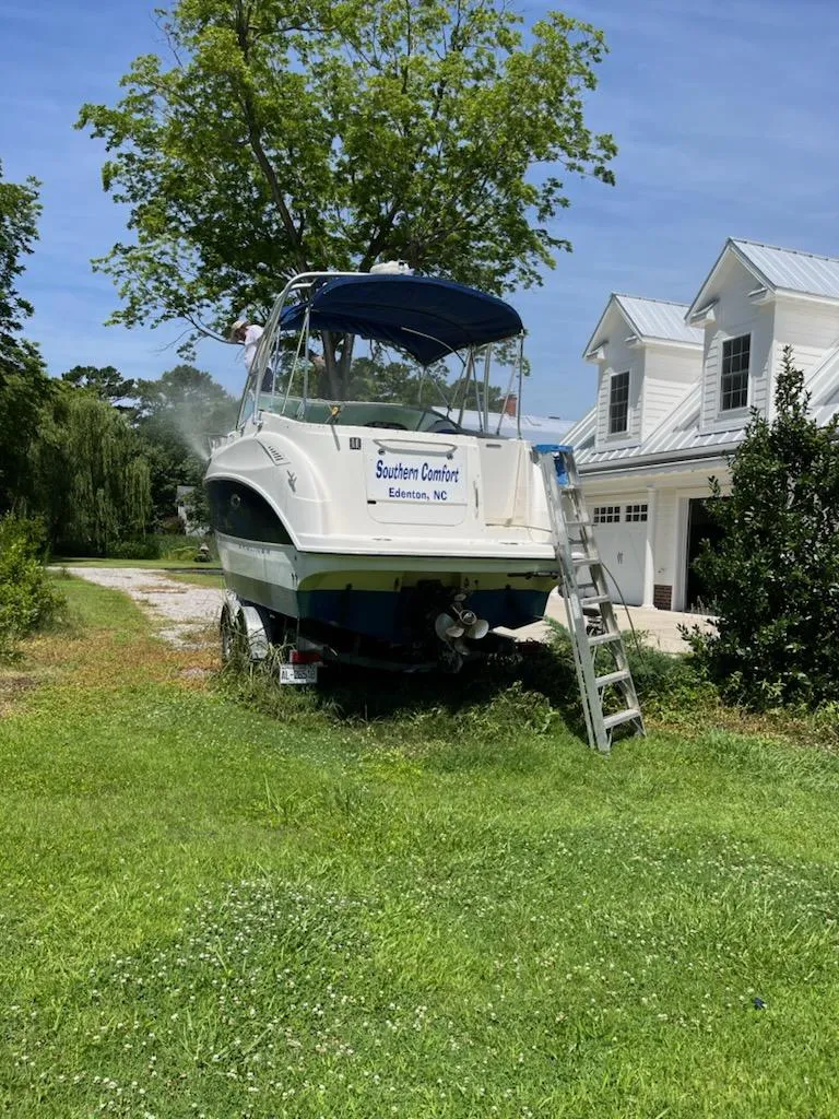 Slide: The Image of 2006 Bayliner 265 Cruiser on grass near a house with ladder access. - 6