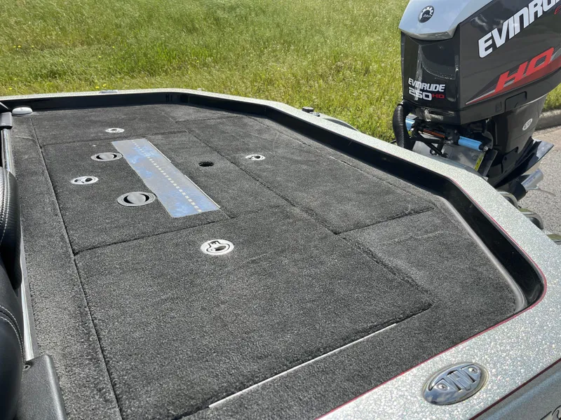 Slide: The Image of 2013 Ranger Z520C boat interior with black leather seats and console, set against grassy background. - 18