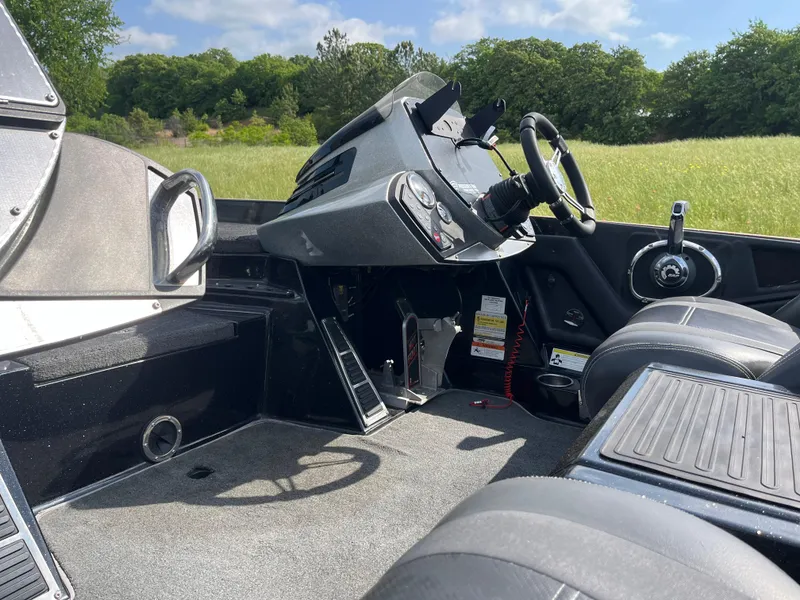 Slide: The Image of 2013 Ranger Z520C boat deck with Evinrude motor, featuring storage compartments and ruler. - 19