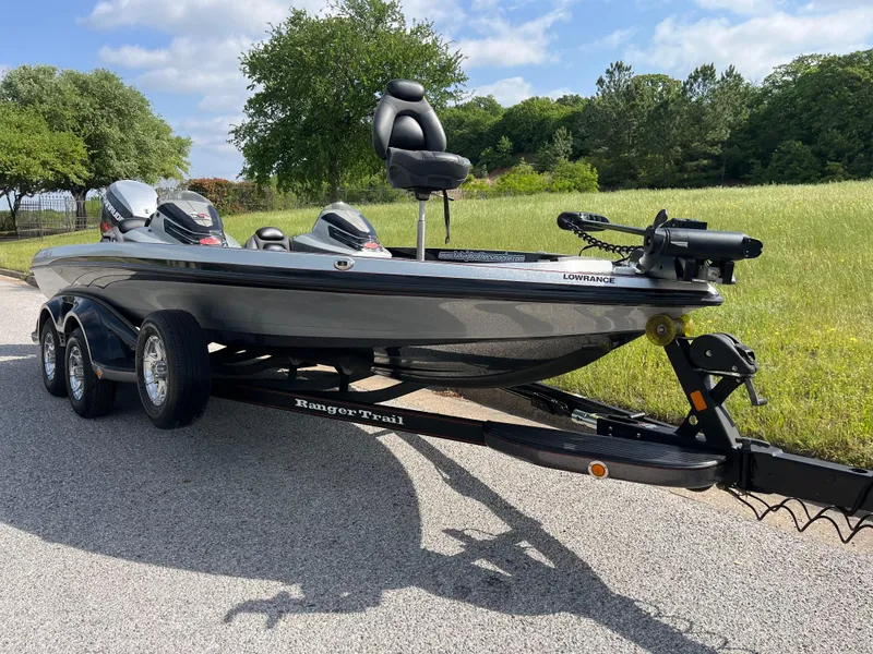 Slide: The Image of 2013 Ranger Z520C boat on trailer, parked on roadside with trees and buildings in background. - 23