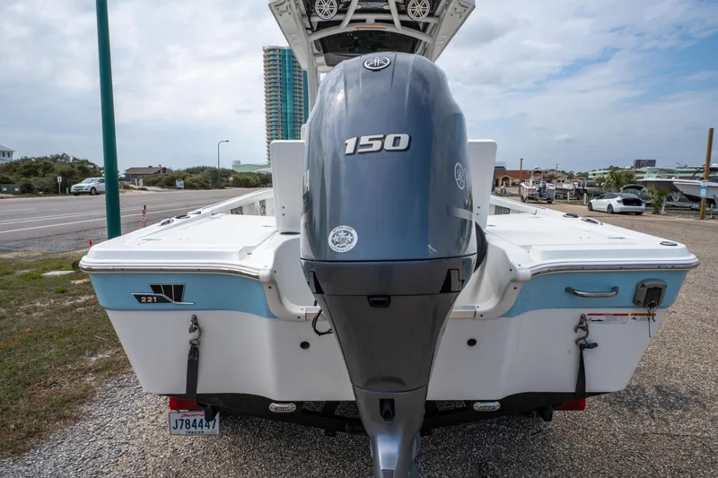 Slide: The Image of 2021 Wellcraft 221 Bay boat with 150 HP engine, parked outdoors. - 12