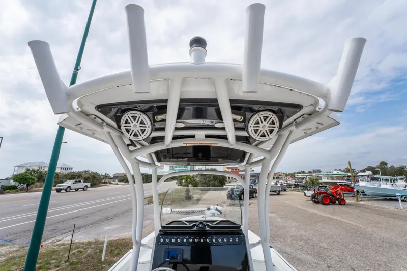 Slide: The Image of 2021 Wellcraft 221 Bay boat with T-top and rod holders, docked near a road. - 22