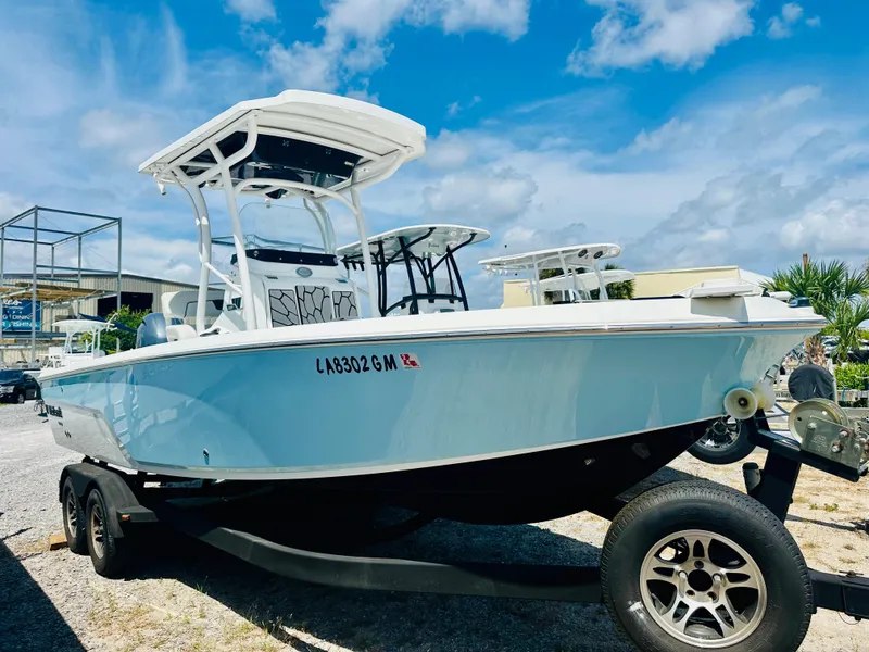 Slide: The Image of 2021 Wellcraft 221 Bay boat on trailer under a clear blue sky. - 3