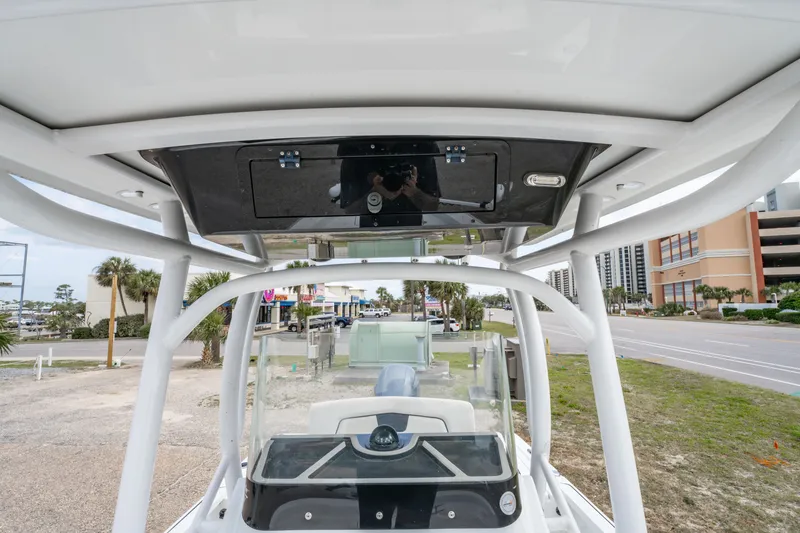 Slide: The Image of 2021 Wellcraft 221 Bay boat console with T-top and urban background. - 30