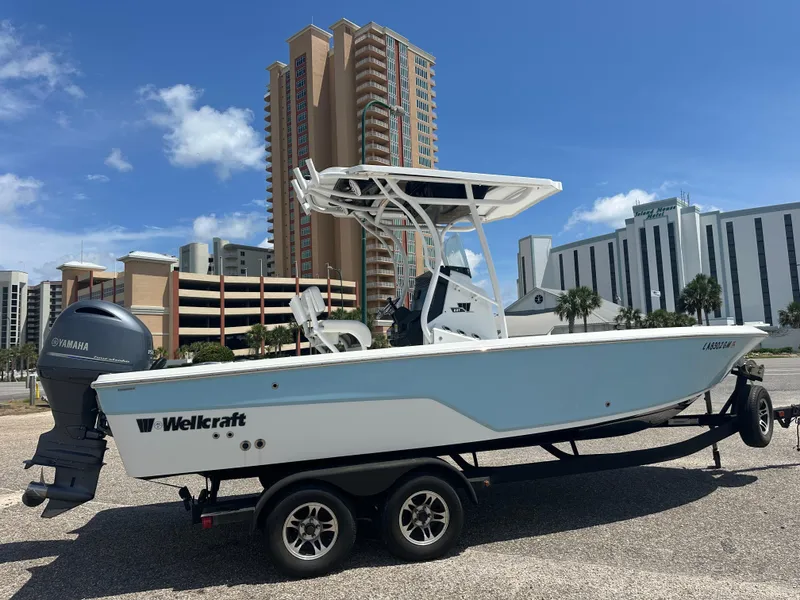 Slide: The Image of 2021 Wellcraft 221 Bay boat on trailer, cityscape background, clear sky. - 7