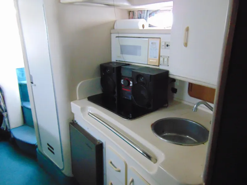 Slide: The Image of 1995 Sea Ray 290DA boat interior with kitchenette, sink, and speakers. - 11