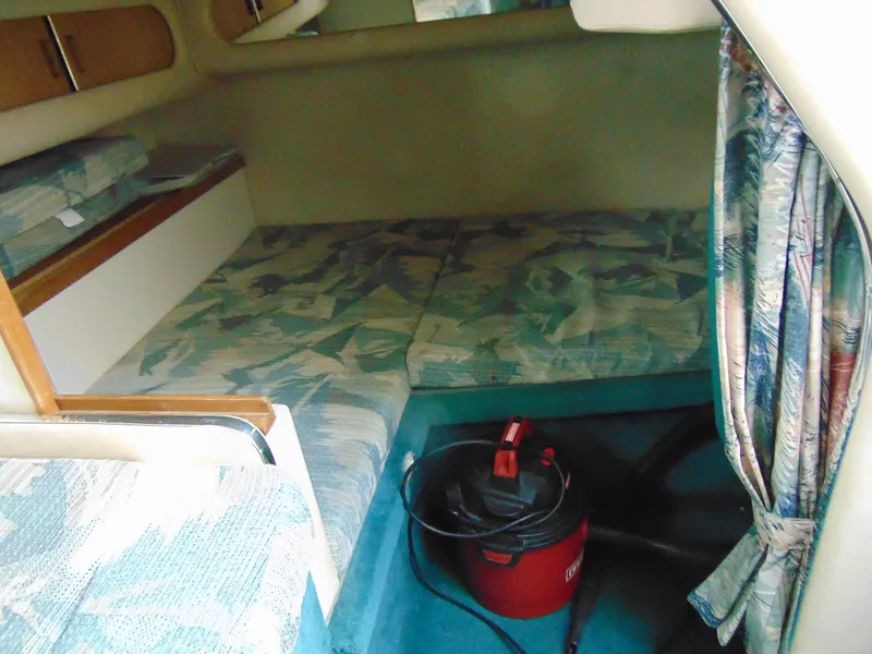 Slide: The Image of 1995 Sea Ray 290DA cabin interior with patterned cushions and a vacuum cleaner. - 15