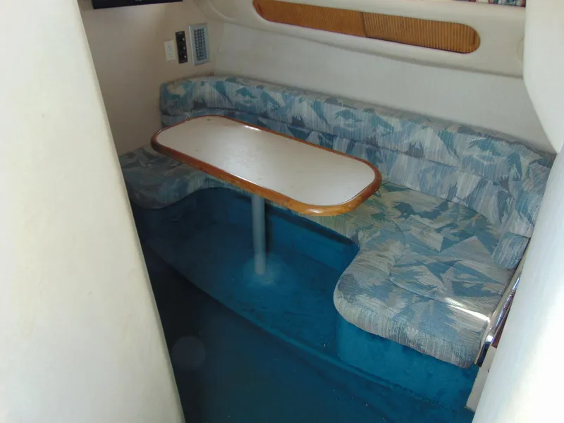 Slide: The Image of 1995 Sea Ray 290DA cabin interior with patterned seating and dining table. - 16