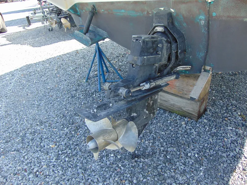 Slide: The Image of 1995 Sea Ray 290DA boat propeller and stern drive on gravel surface. - 9
