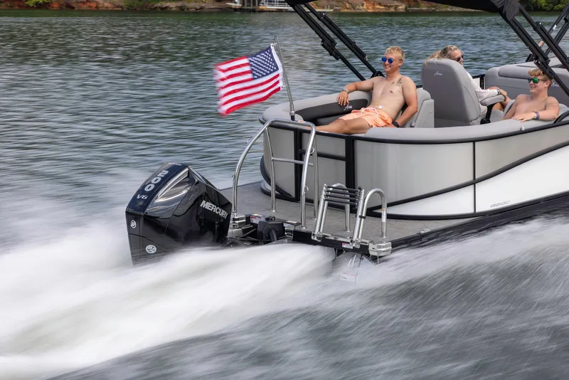 Slide: The Image of 2025 Barletta ARIA 22QC pontoon boat cruising on a lake with passengers relaxing. - 9