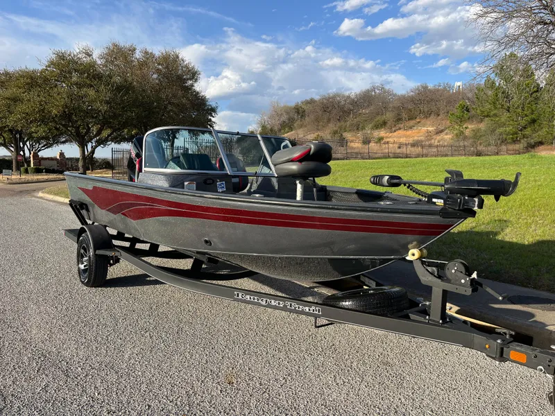Slide: The Image of 2021 Ranger VS1782 WT fishing boat on trailer, parked on a road with trees in background. - 11
