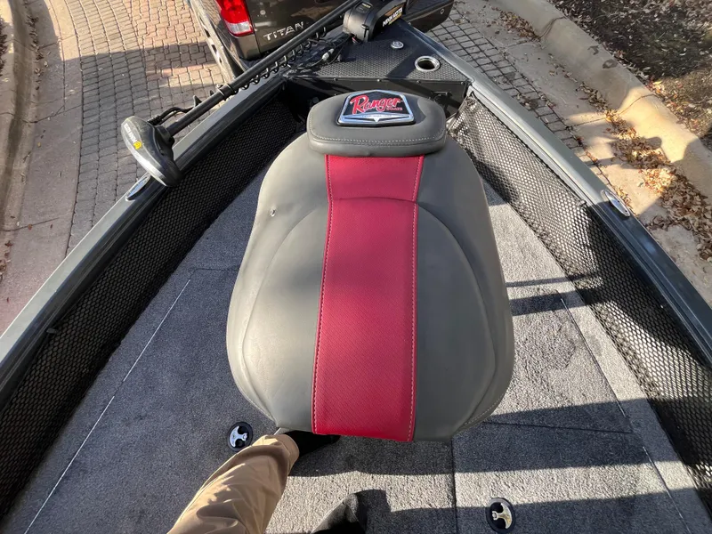 Slide: The Image of 2021 Ranger VS1782 WT boat seat with red and gray upholstery, on a textured deck. - 27