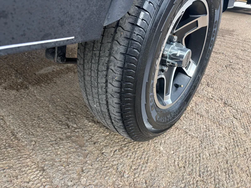 Slide: The Image of 2021 Ranger VS1782 WT tire on textured ground, showcasing tread and alloy wheel. - 52