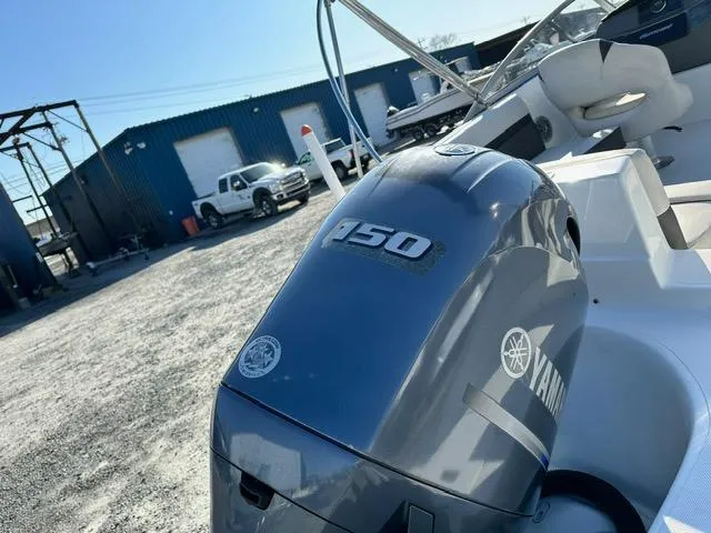 Slide: The Image of 2018 Godfrey Hurricane 217SD boat with Yamaha 150 engine in a marina setting. - 18