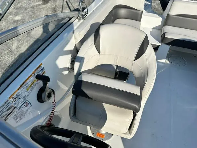 Slide: The Image of 2018 Godfrey Hurricane 217SD boat interior with steering wheel and cushioned seating. - 5