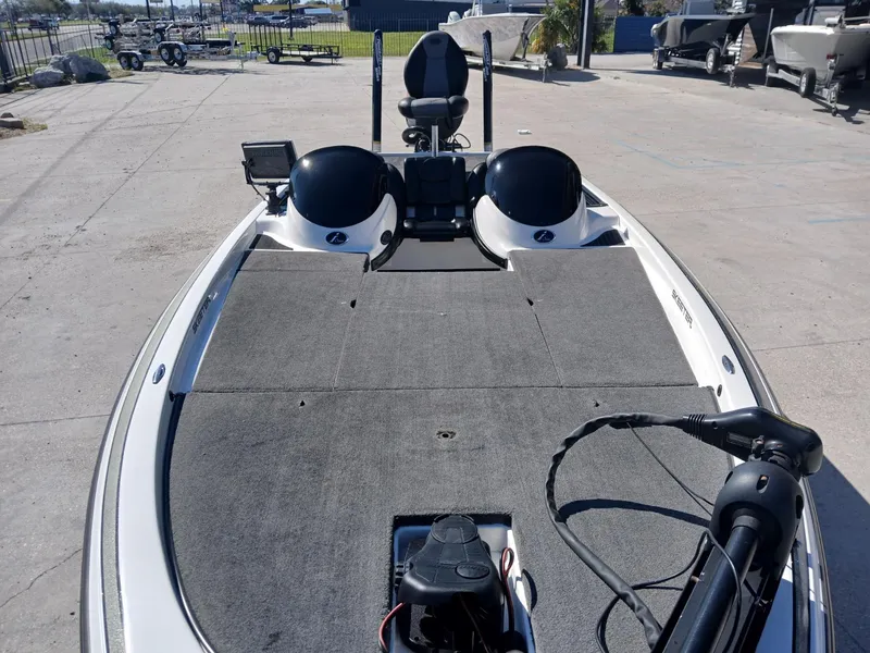 Slide: The Image of 2006 Skeeter 21 boat with spacious deck and fishing equipment, parked on concrete surface. - 11
