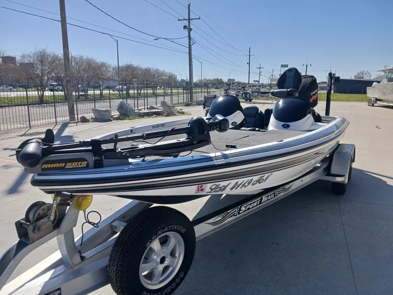 Slide: The Image of 2006 Skeeter 21 boat on trailer, equipped with trolling motor, parked outdoors. - 13