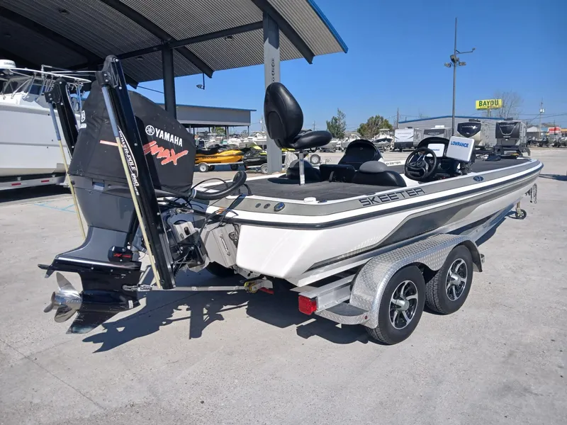 Slide: The Image of 2006 Skeeter 21 boat with Yamaha engine on a trailer in a marina. - 17