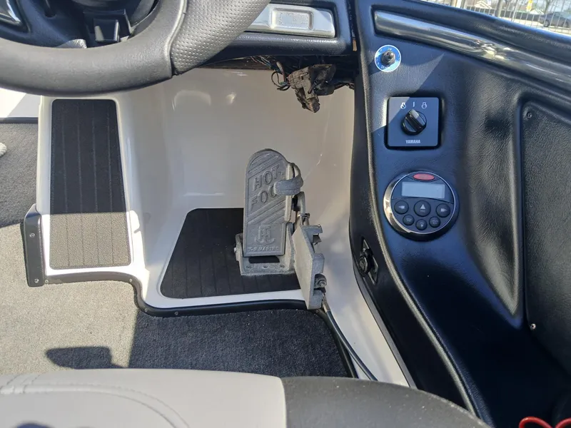 Slide: The Image of 2006 Skeeter 21 boat interior, showing steering wheel, foot pedal, and control panel. - 2