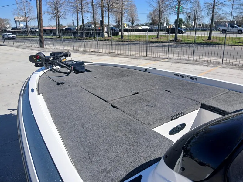 Slide: The Image of 2006 Skeeter 21 boat deck with trolling motor, parked outdoors. - 6