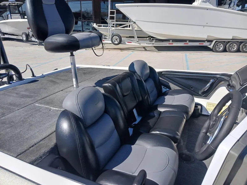 Slide: The Image of 2006 Skeeter 21 boat interior with gray and black seating, featuring a raised fishing chair. - 9