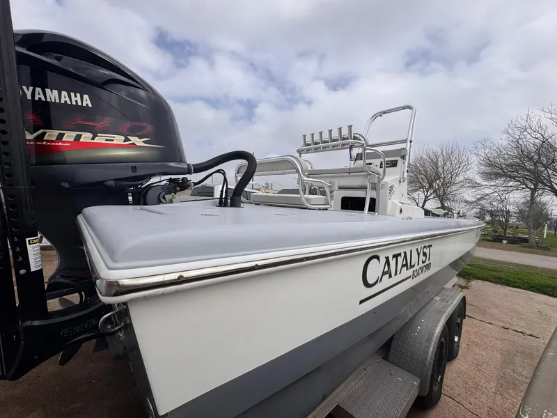 Slide: The Image of 2019 Catalyst 260 Catamaran with Yamaha engine on trailer, parked outdoors. - 2