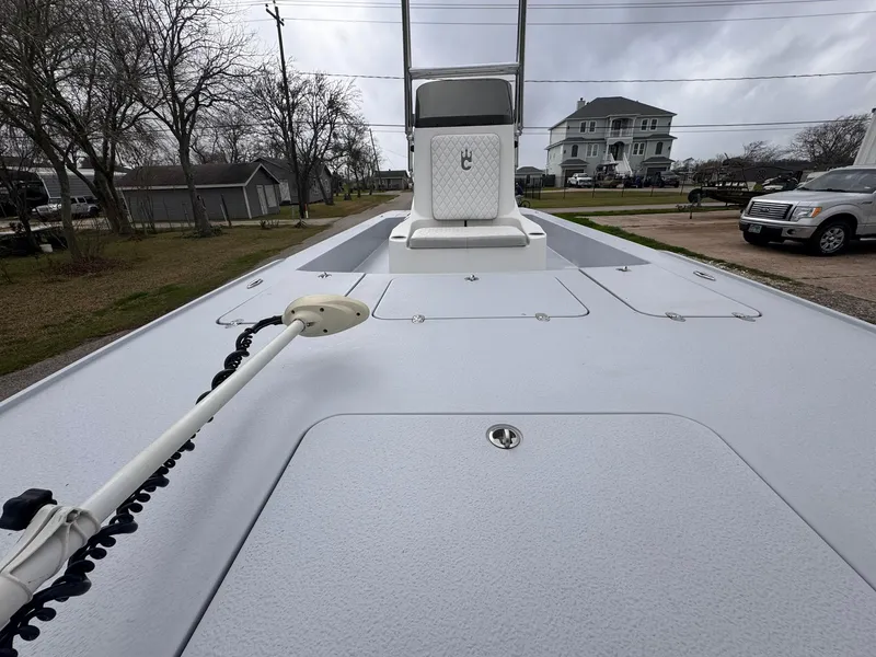 Slide: The Image of 2019 Catalyst 260 Catamaran deck view with trolling motor, parked near residential area. - 9