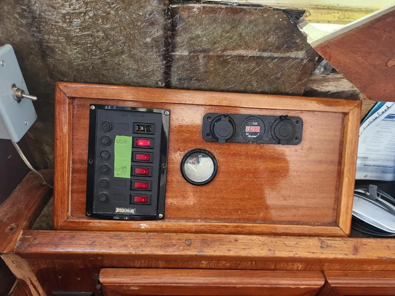 Slide: The Image of 1977 Pacemaker 40 Sportfisherman control panel with switches and gauges on wooden dashboard. - 12