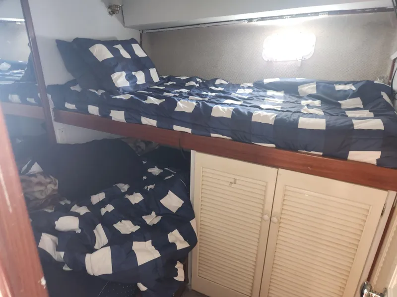 Slide: The Image of Bunk beds with checkered bedding in a 1977 Pacemaker 40 Sportfisherman cabin. - 16